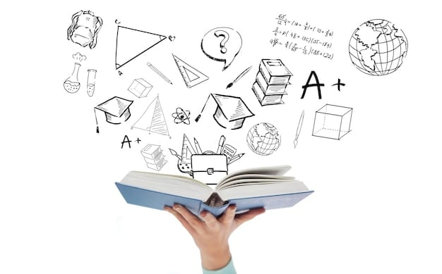Photo education, school and learning concept - close up of woman hand holding open blue book with doodles