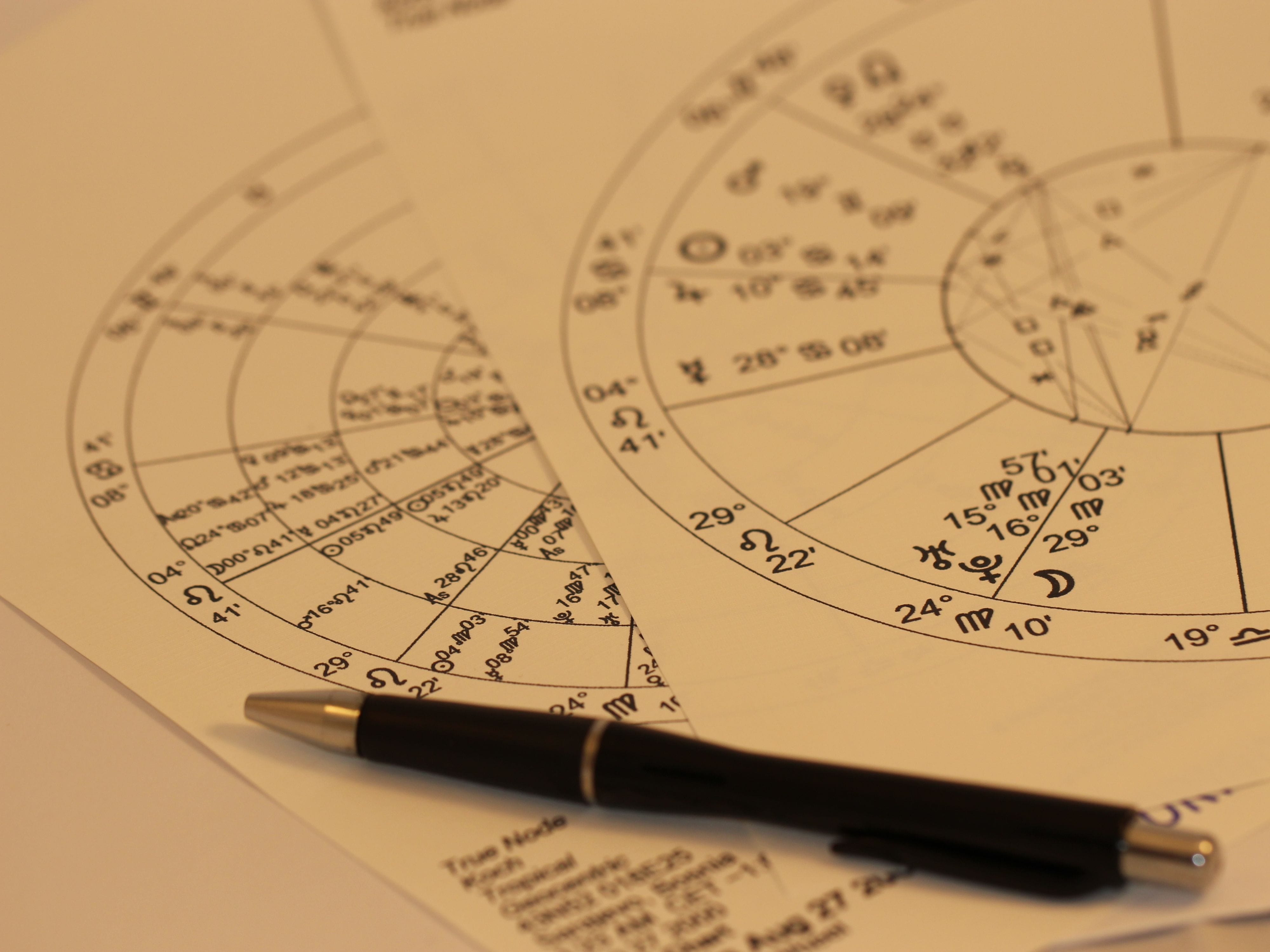 Pen resting on paper with a numerology pattern