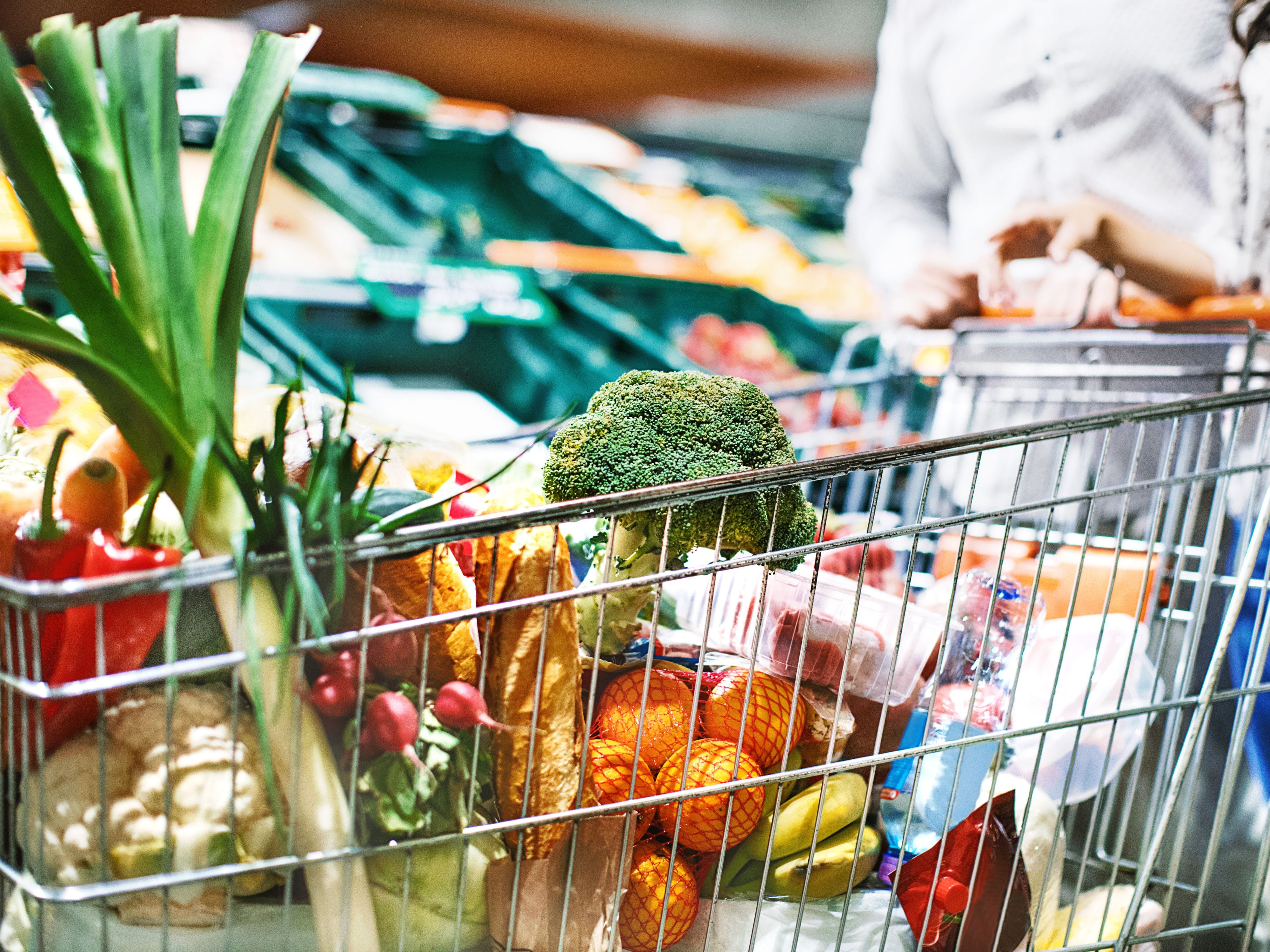 Shopping cart filled with fresh vegetables and fruits