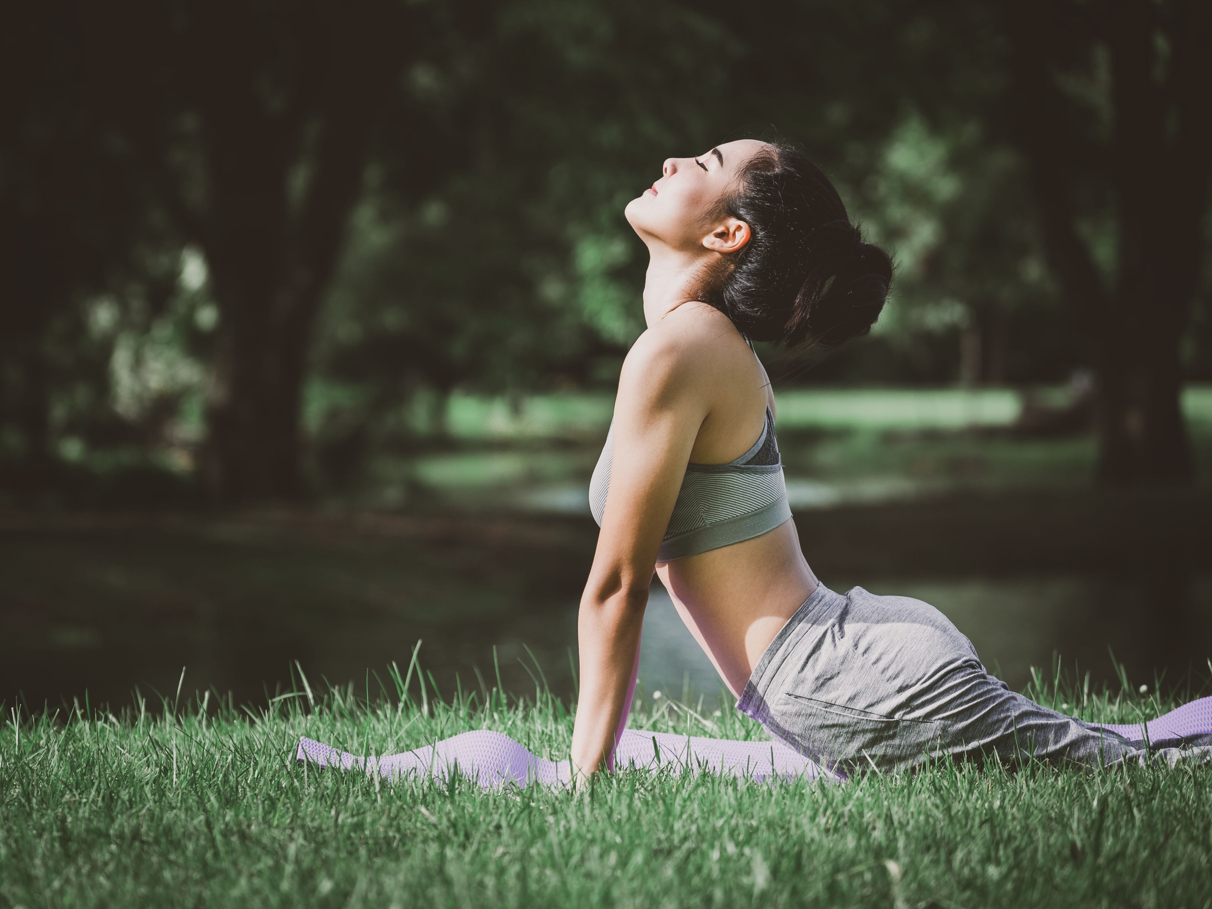 Woman practicing yoga in a serene forest setting