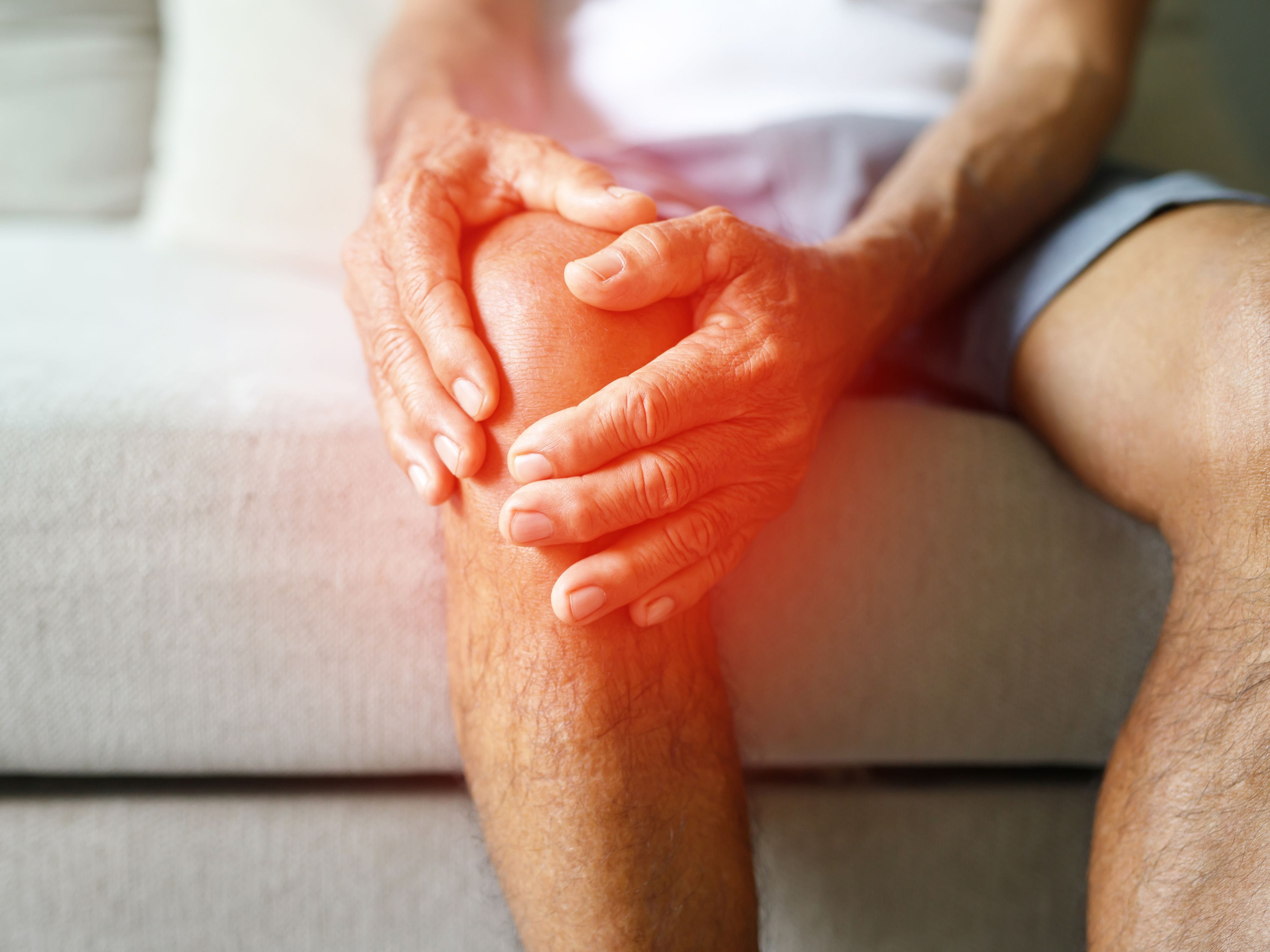 Person holding their knee in pain, symbolizing joint discomfort and inflammation