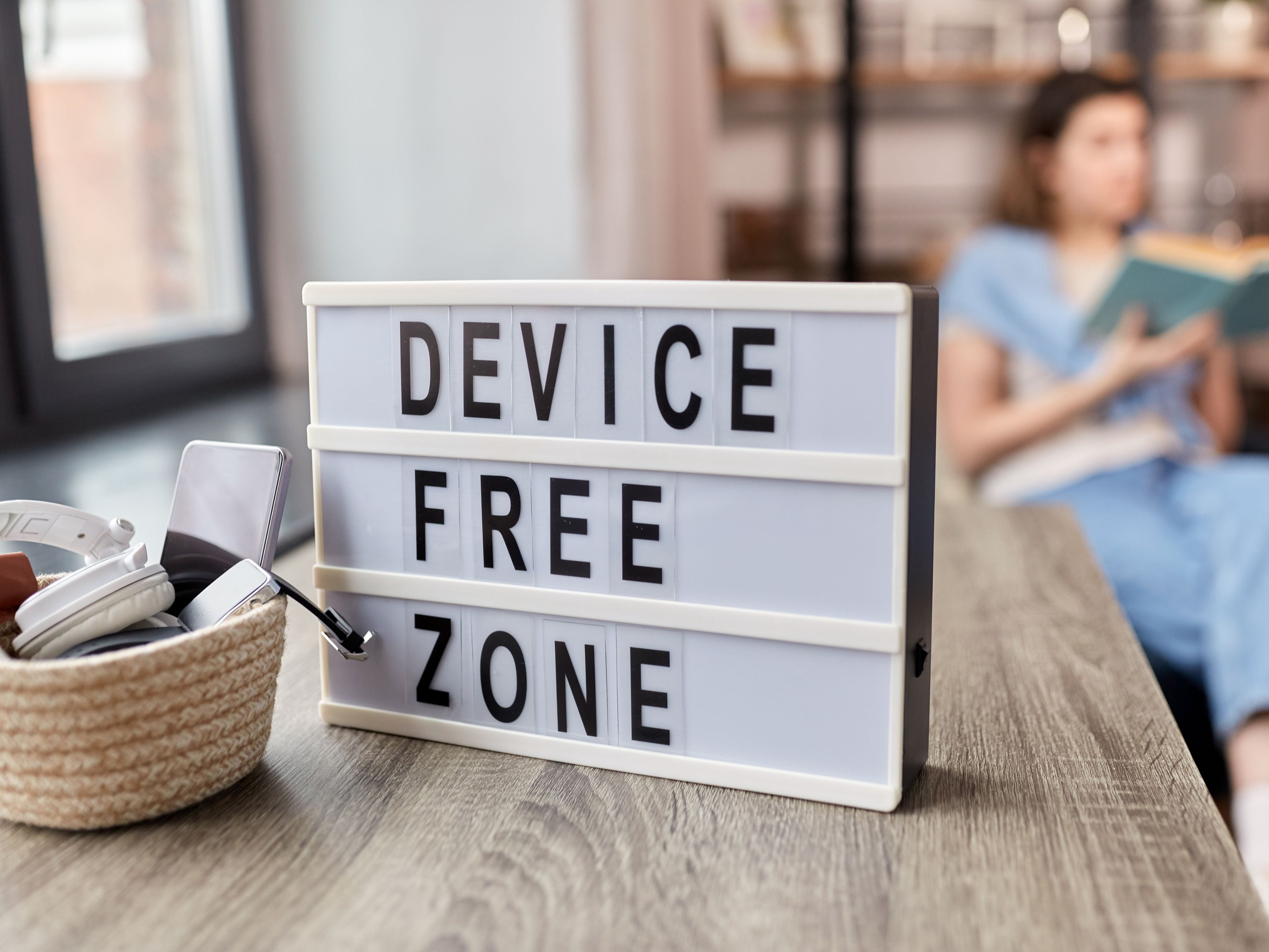 Room with 'Device-Free Zone' sign and a person reading