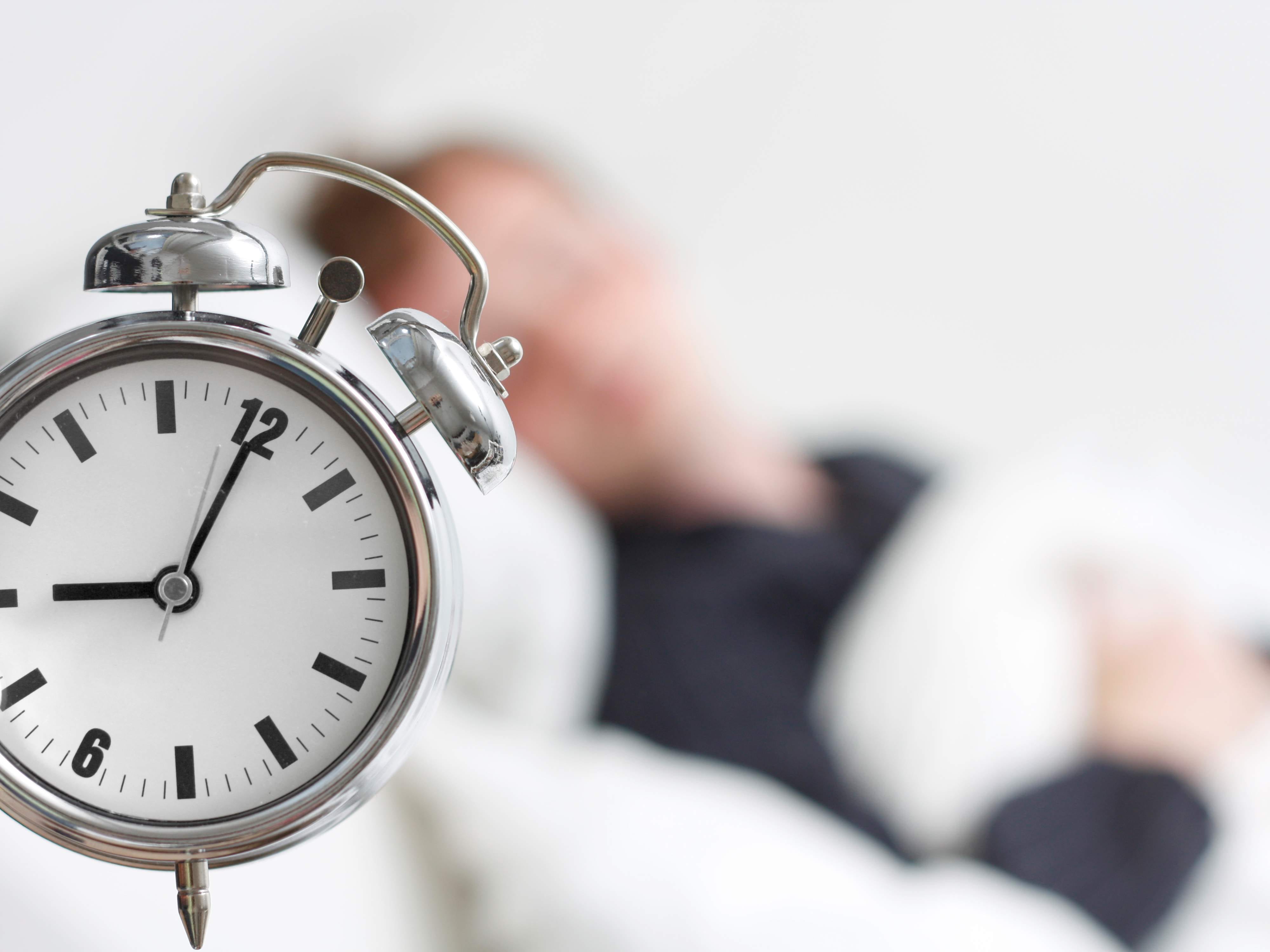 Man sleeping while his alarm snooze rings