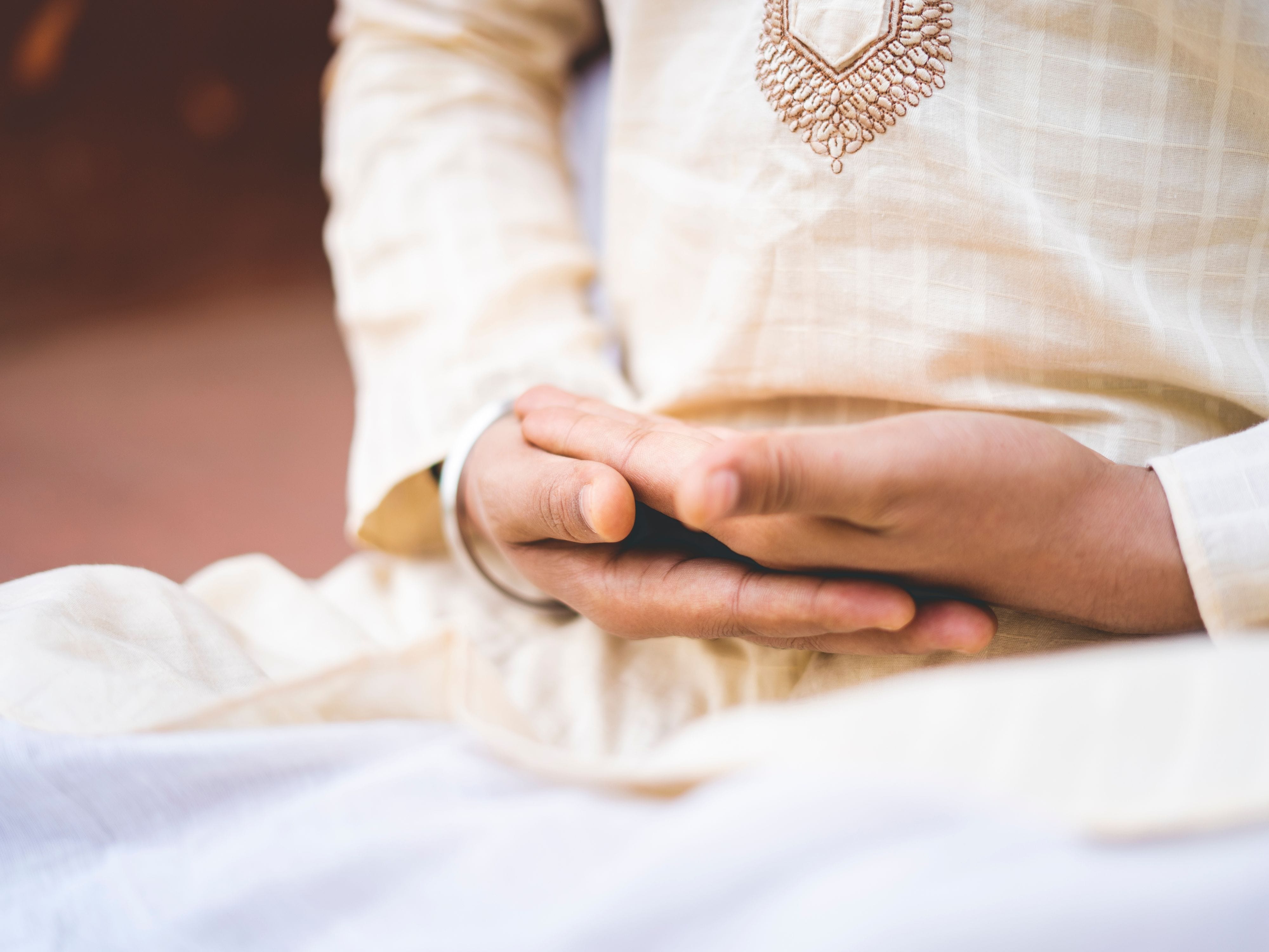 Person practicing pranayama breathing with hands cupped on lap