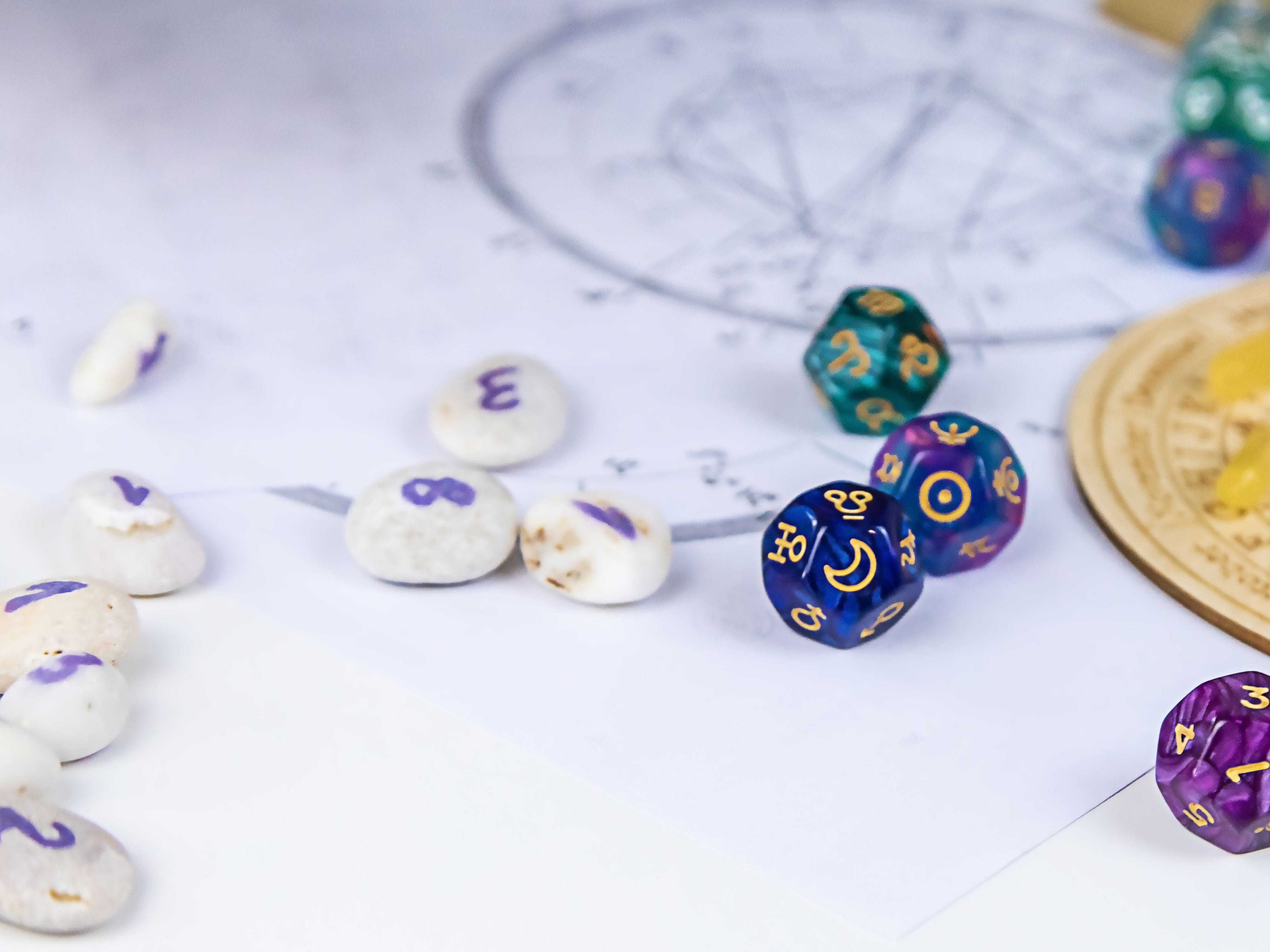 Numbered oval stones and hexagonal dice with cosmic symbols