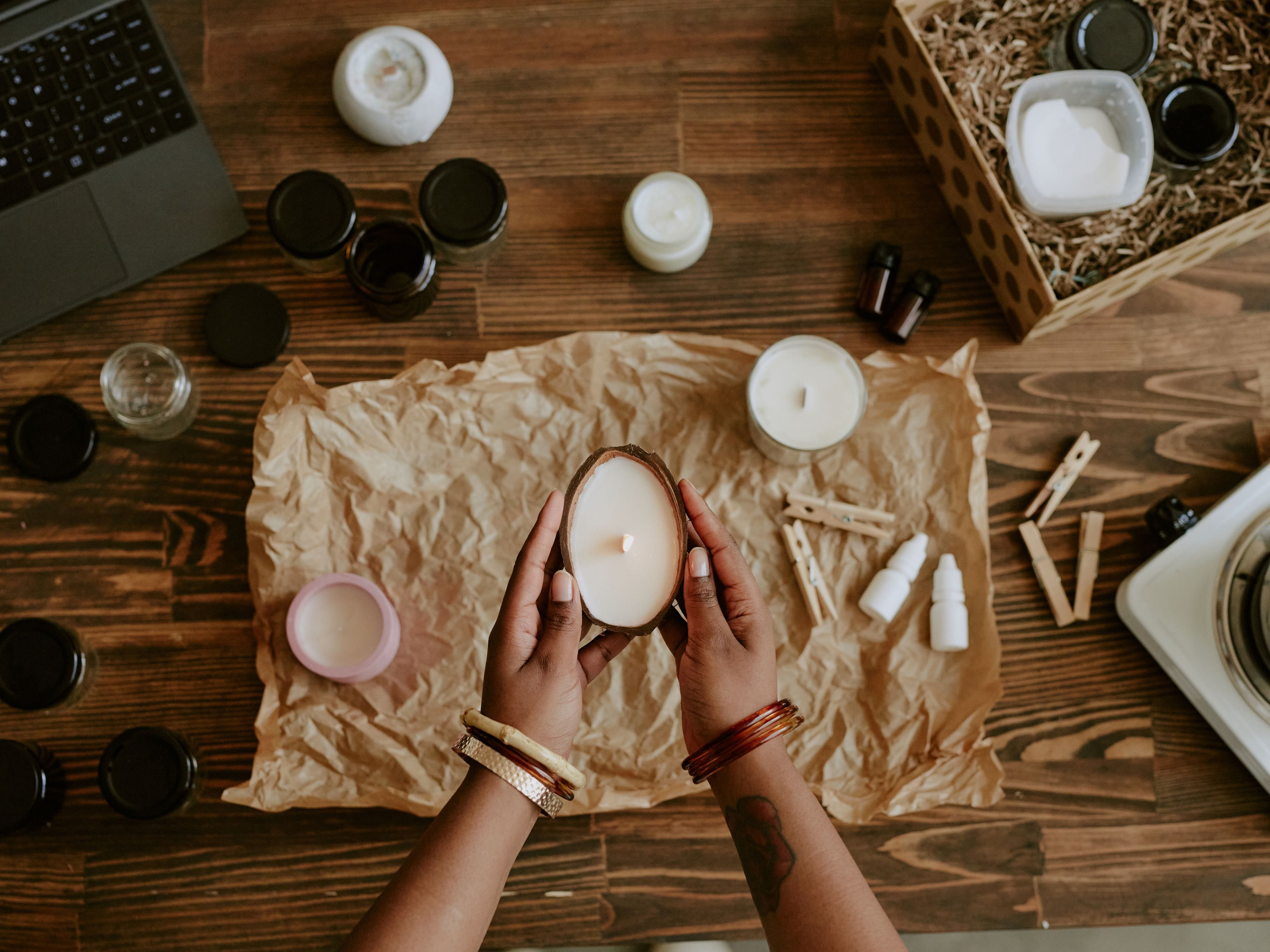 Hand moulding candle wax into an old glass jar for a DIY candle holder