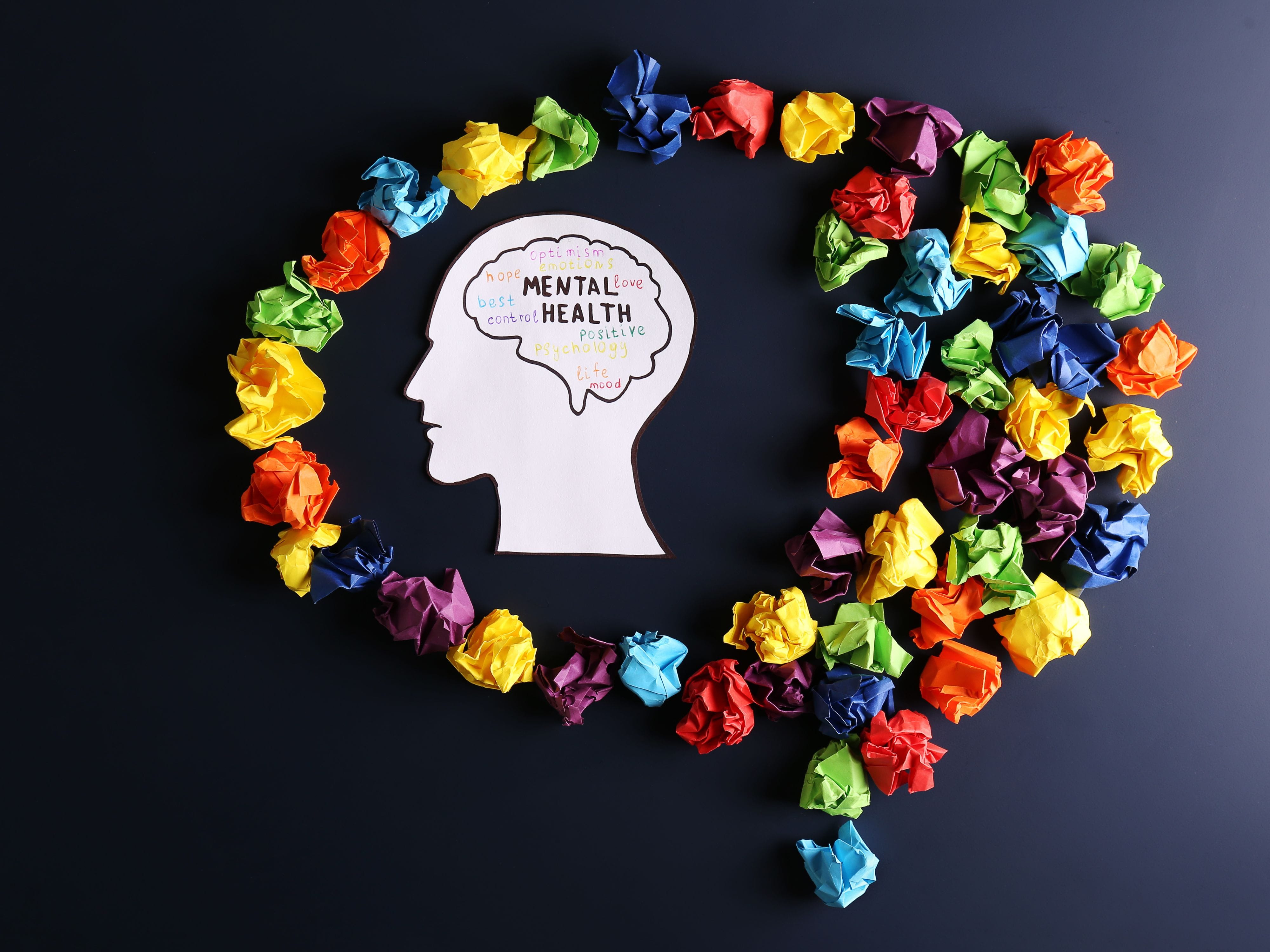 Head with 'mental health' written on it, surrounded by crumpled papers