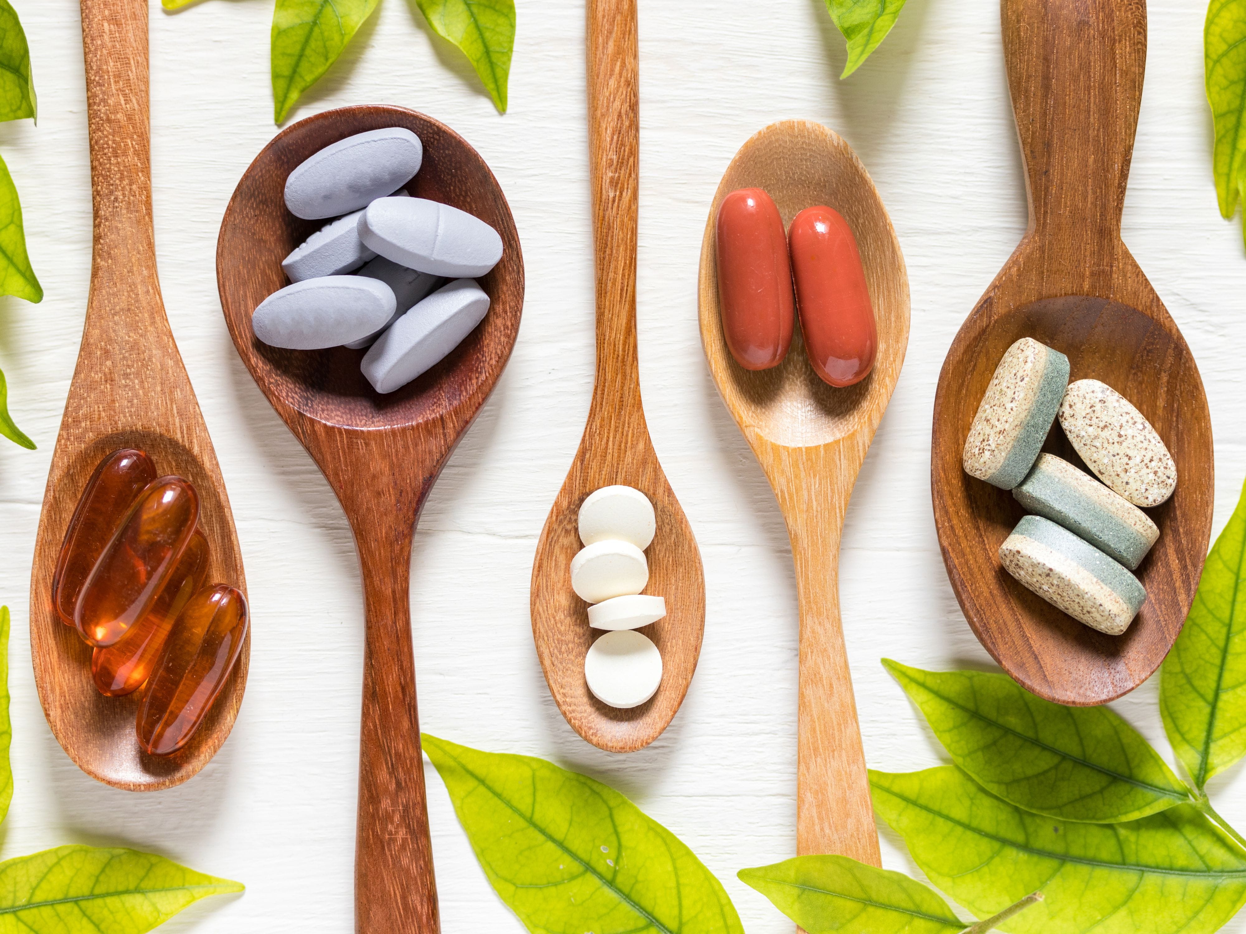 Spoons holding various supplement tablets as food alternatives