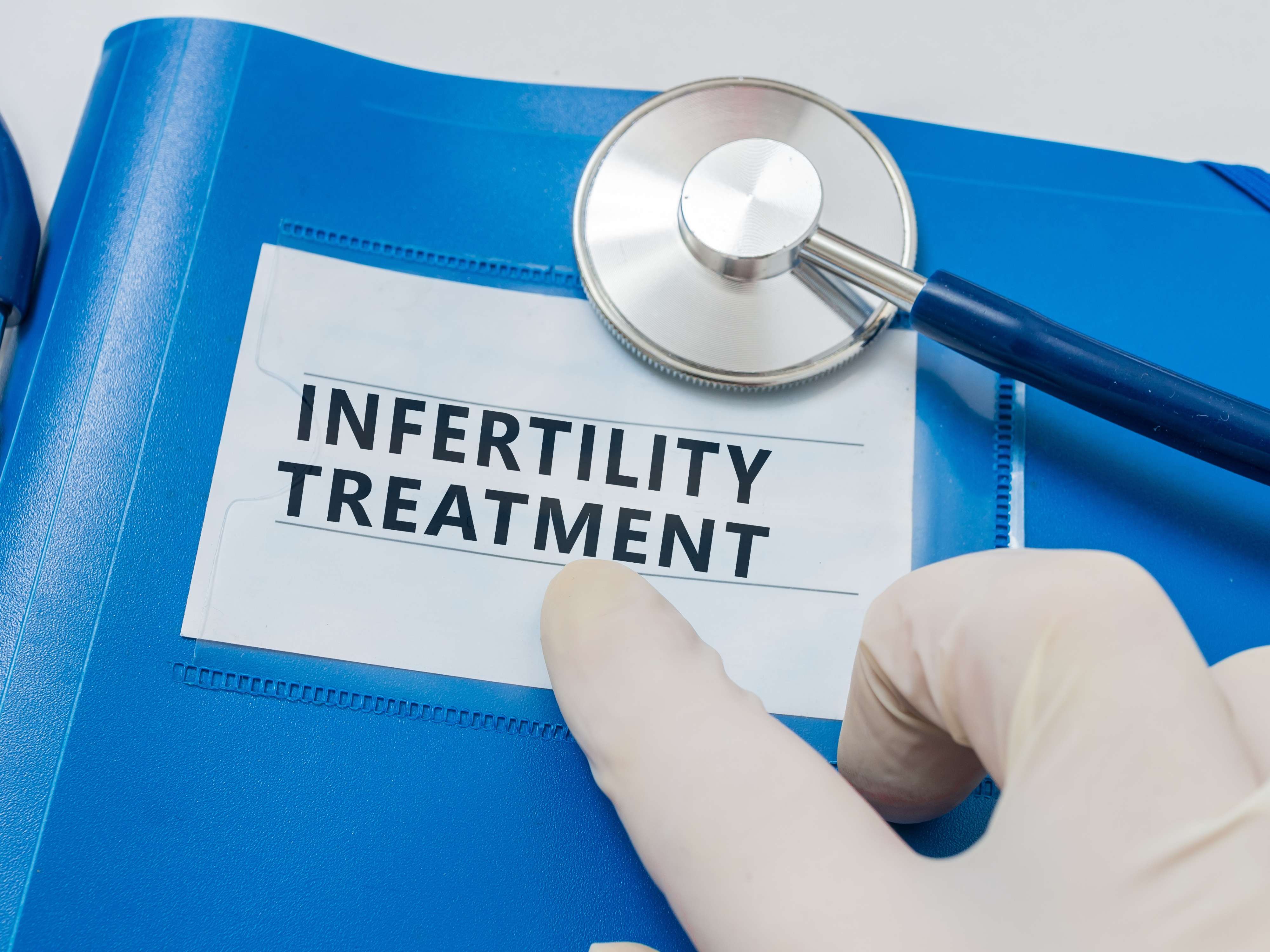 Infertility treatment file with a stethoscope and pointing finger