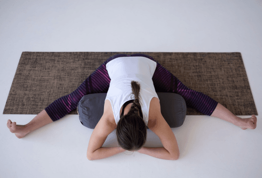 Woman doing wide-angle seated forward bend yoga stretch