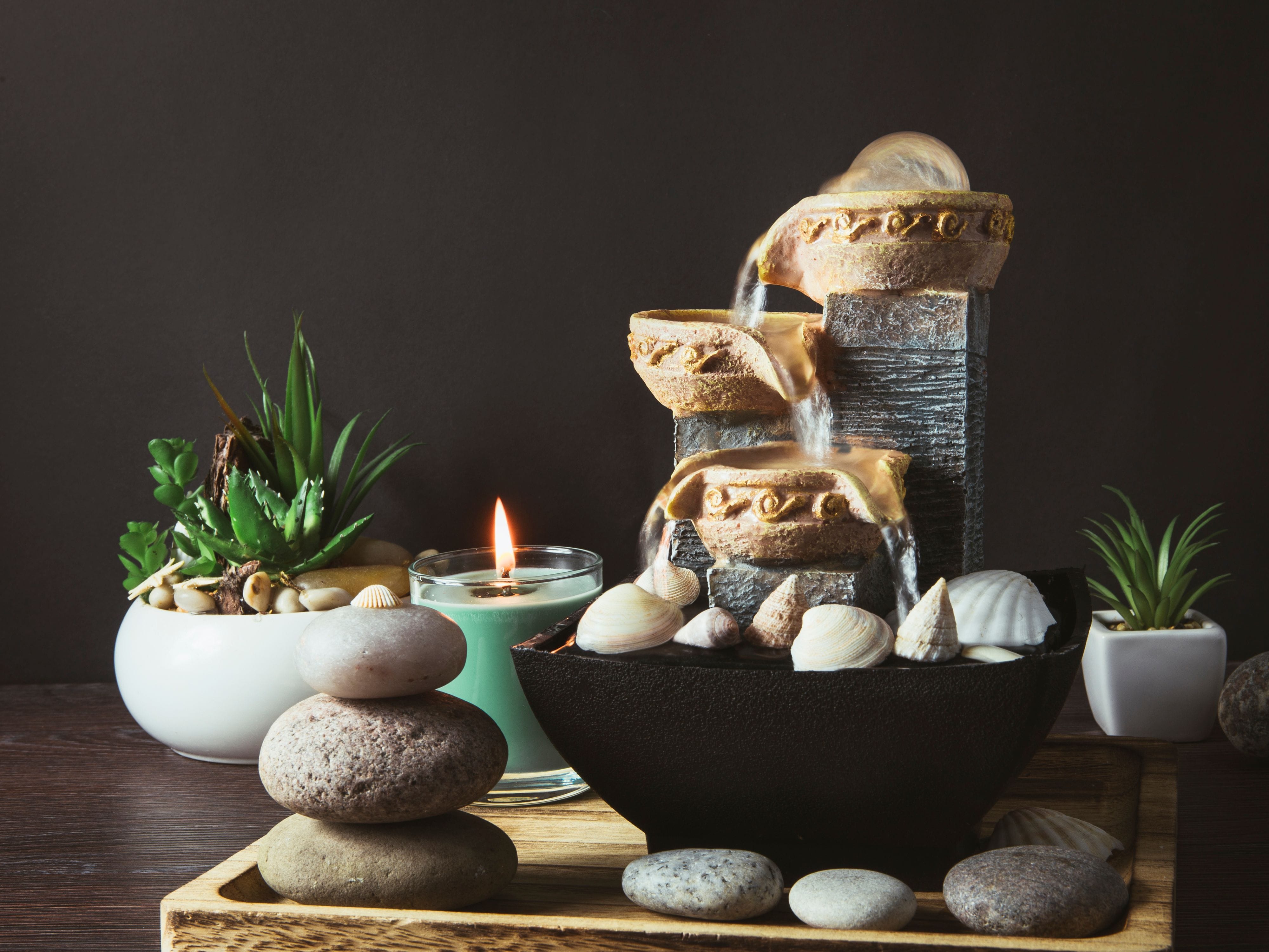 Miniature Water Fountain on a table surrounded by small plants