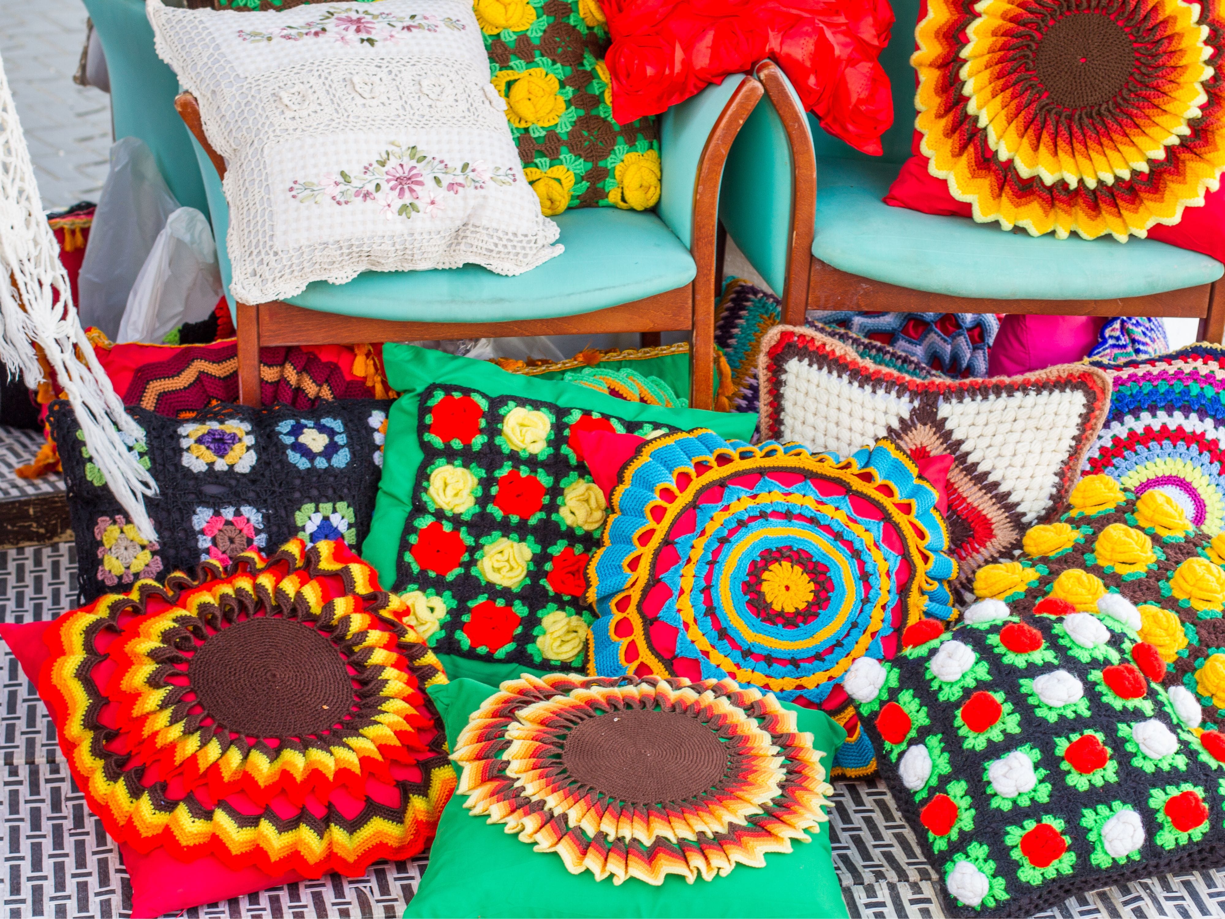 Multiple multicoloured cushions arranged on a decorative bed