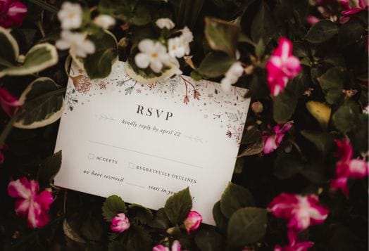 Wedding RSVP card among flowers