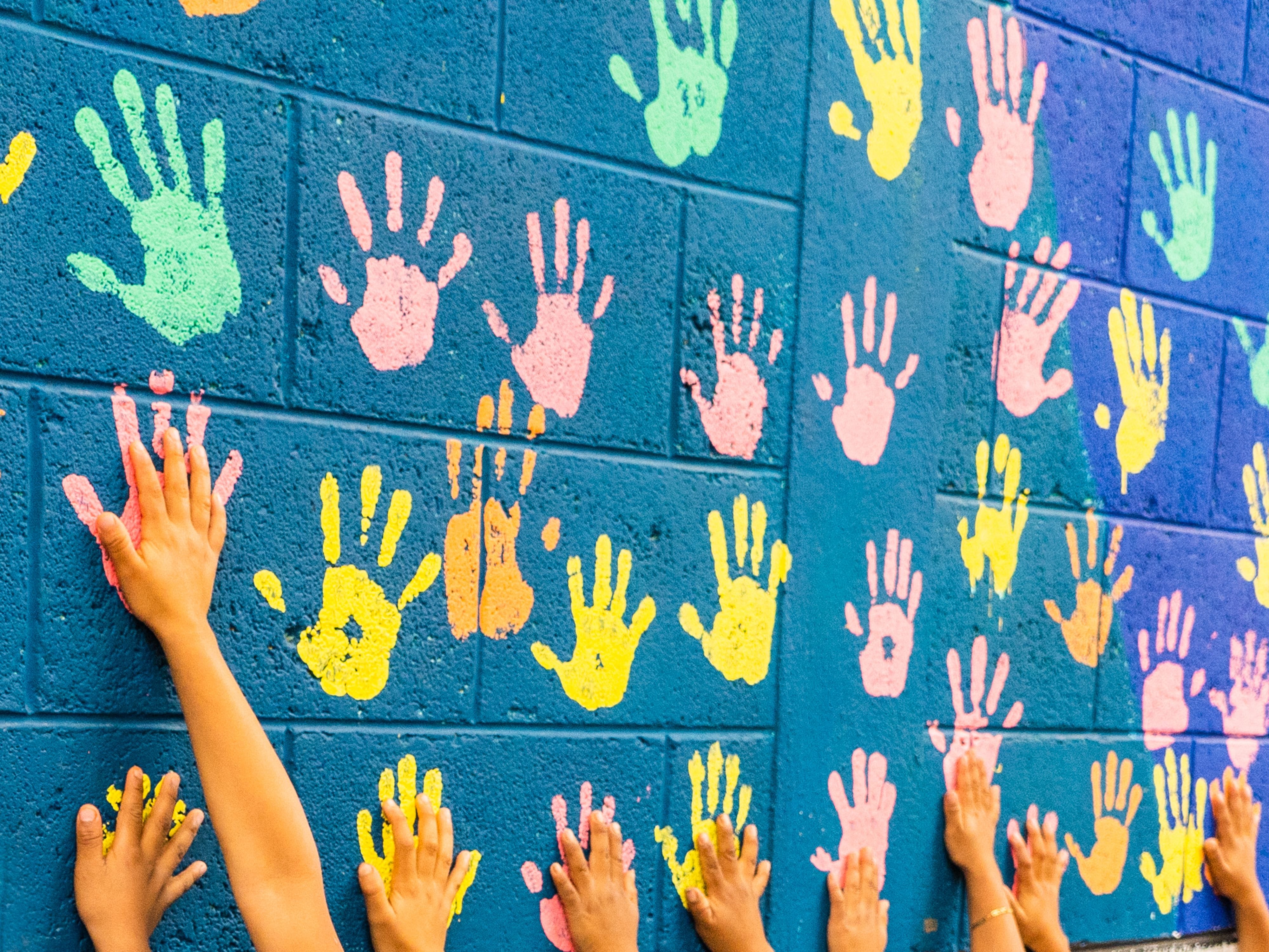 Colorful handprints on a blue wall