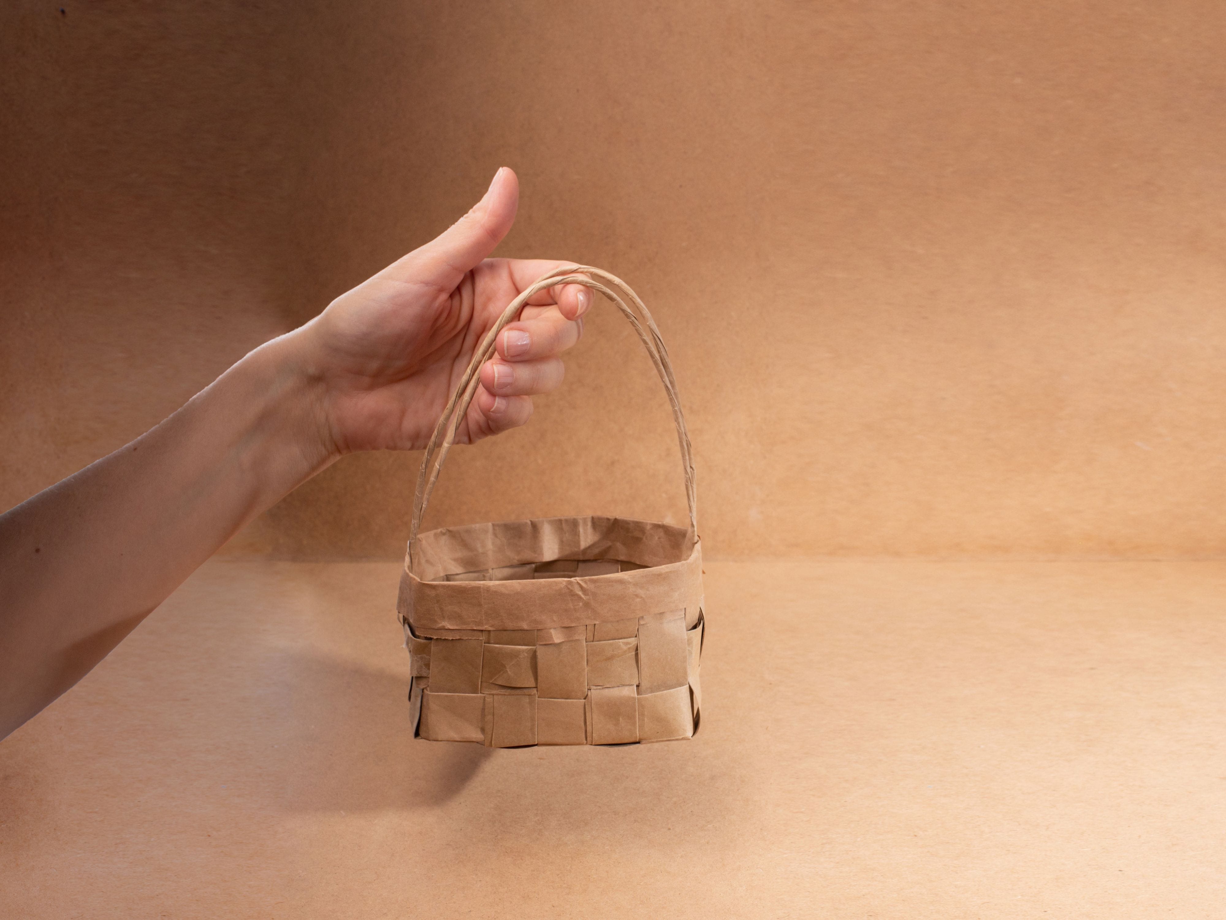 Hand holding small woven paper basket