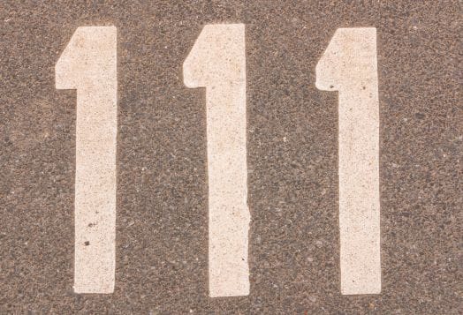 The number "111" painted in white on a textured asphalt surface