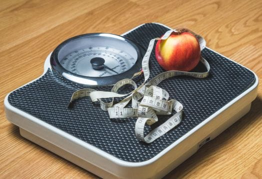 Scale with apple and measuring tape
