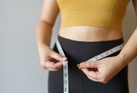 Woman measuring waist with tape