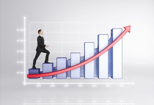 Businessman climbing a rising bar graph