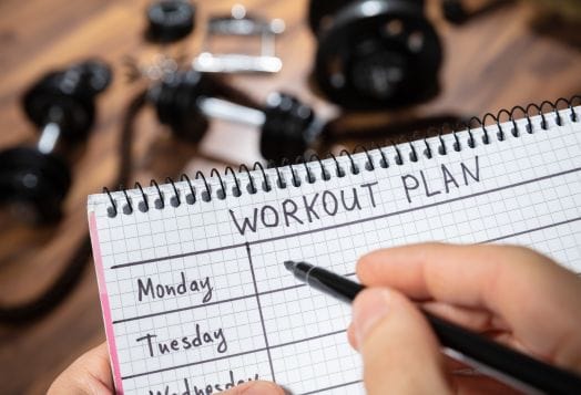 Writing a workout plan in a notebook