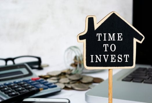 House-shaped sign saying "TIME TO INVEST"