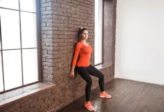Woman doing a wall sit exercise