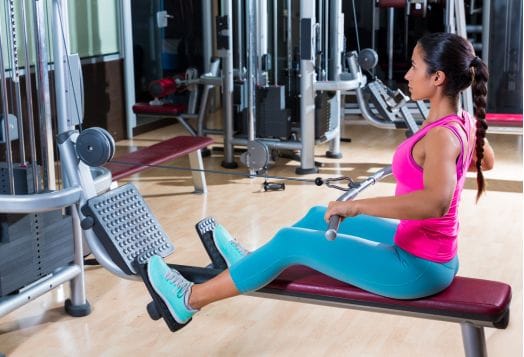 Woman using a seated row machine at the gym