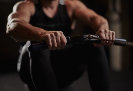 Close-up of hands gripping a rowing machine bar