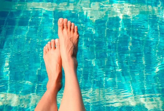 Feet dangling in a swimming pool
