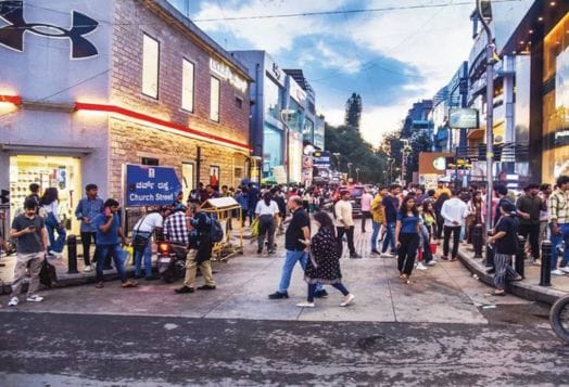 Bustling Church Street in Bengaluru with people, shops, and cafes