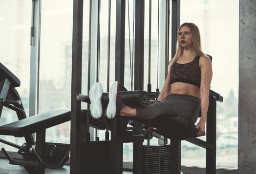 Woman using a leg extension machine at a gym