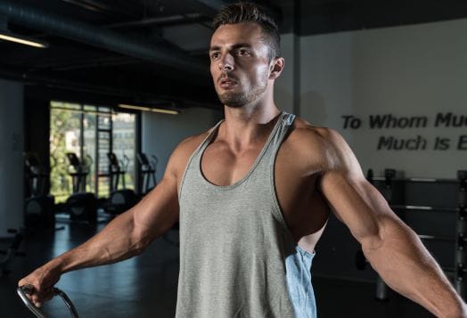 Man doing a cable lateral raise at a gym