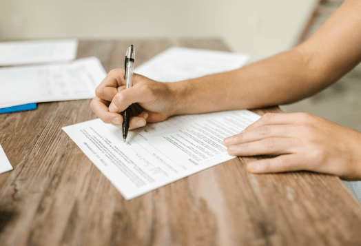 Person's hand writing on a document