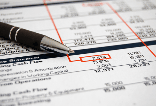 A close-up of a financial statement with a pen resting on it