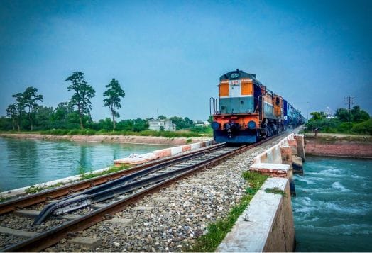 An Indian Railways train crossing a bridge over a river