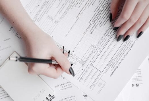 Woman's hands writing on tax forms