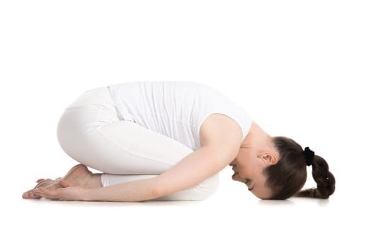 Woman in child's pose, white background