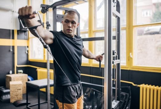 Man using a cable machine for chest flyes