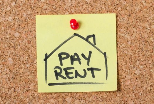 "PAY RENT" note pinned to corkboard