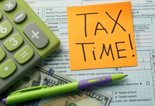 An orange sticky note reads "TAX TIME!" next to a calculator