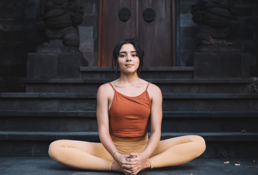 Woman meditating in bound angle pose outdoors