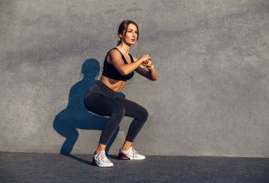 Woman performing a squat against a wall
