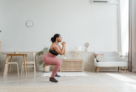 Woman squatting in living room