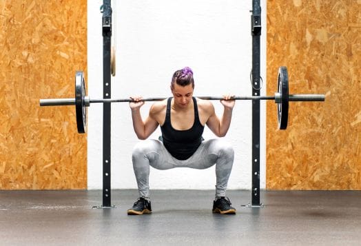 Woman weightlifting, barbell on shoulders