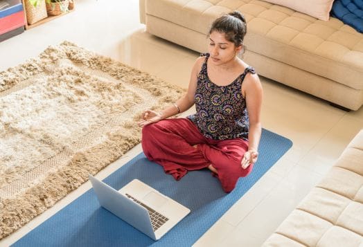 Woman meditating with laptop