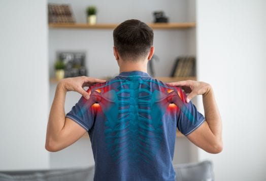 Man in blue shirt with glowing shoulders demonstrating shoulder rolls