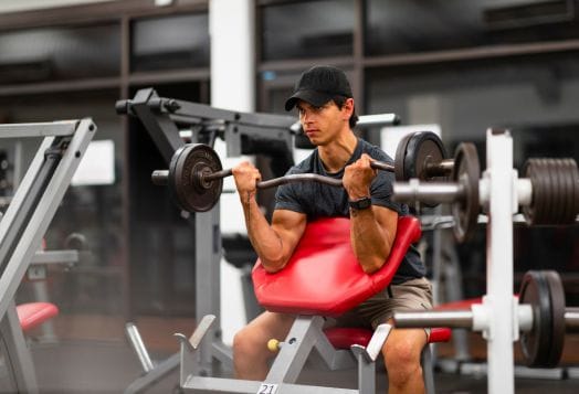 Man in black cap doing bicep curls