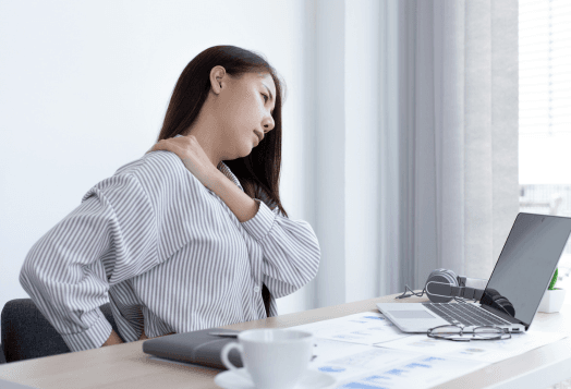Woman experiencing neck and back pain at her desk