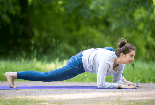 Woman demonstrating Lizard Pose or Utthan Pristhasana yoga pose on a mat
