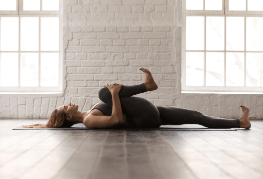 A woman practices Reclined Knee Circles